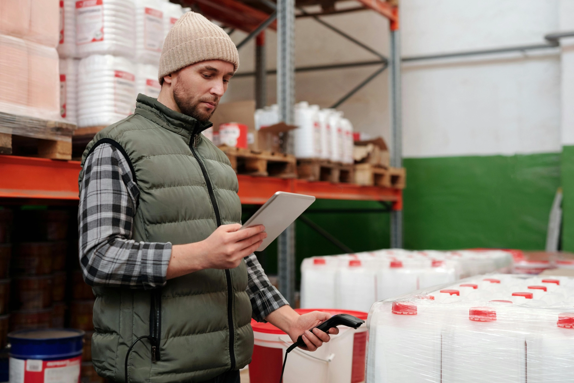 A warehouse worker holding a tablet device and scanning items