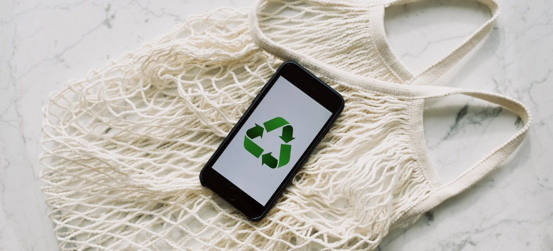 Eco-friendly and sustainable bag for shopping with a phone displaying the recycle sign